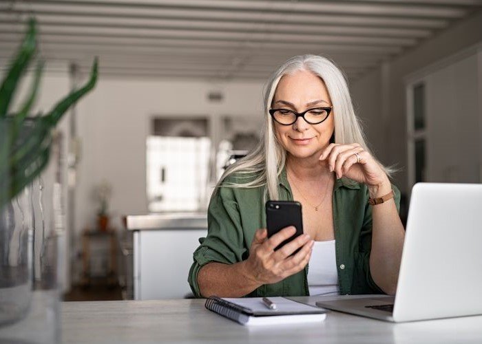 Older person smiling looking at their phone