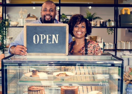 Happy couple with open sign