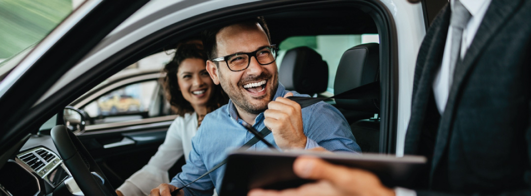 Happy couple in their new car. 